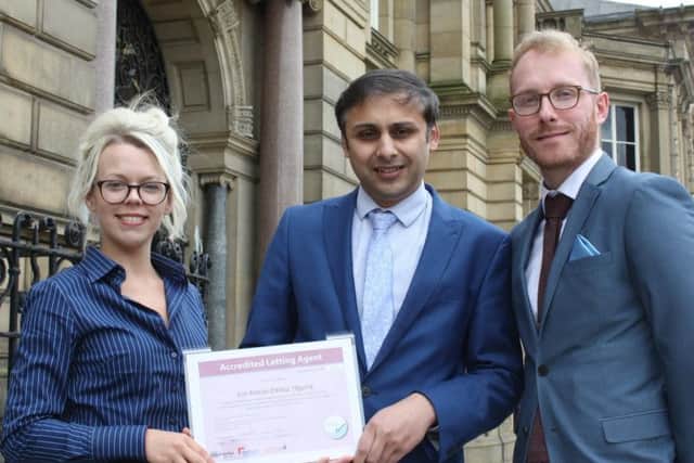 Burnley Council chief operating officer Lukman Patel (centre) presents company director Gareth Hooley and lettings manager Laura Stockdale, of Jon Simon estate agents, with its certificate.