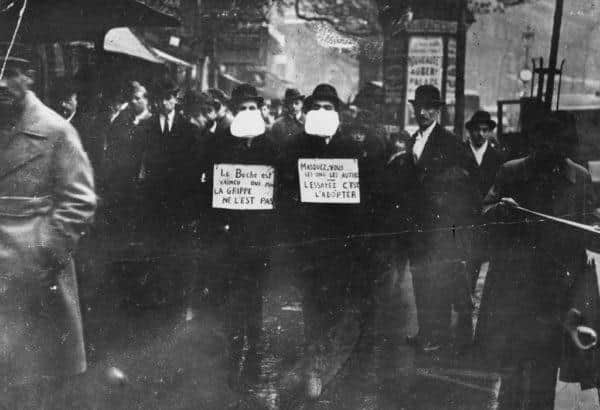 Two men wearing and advocating the use of flu masks in Paris during the Spanish flu epidemic (Photo: Topical Press Agency/Getty Images)