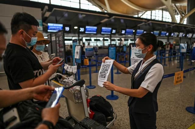 Passengers scan a health code which reveals their vaccination status and Covid test results (Photo: Getty Images)